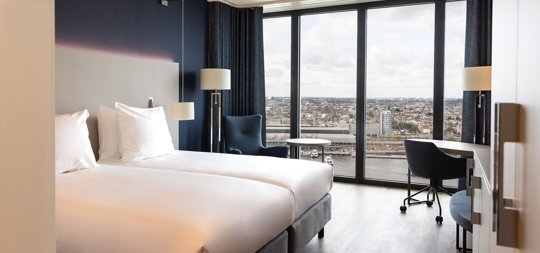 Twin room in Maritim Hotel Amsterdam with large window and panoramic city view