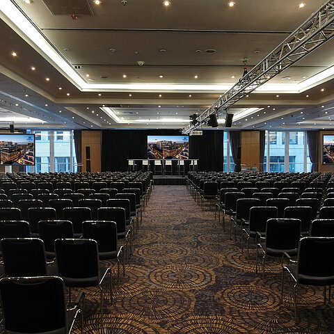 Gran sala de reuniones con equipos modernos y sillas en fila en el hotel Maritim proArte, ideal para conferencias y eventos.