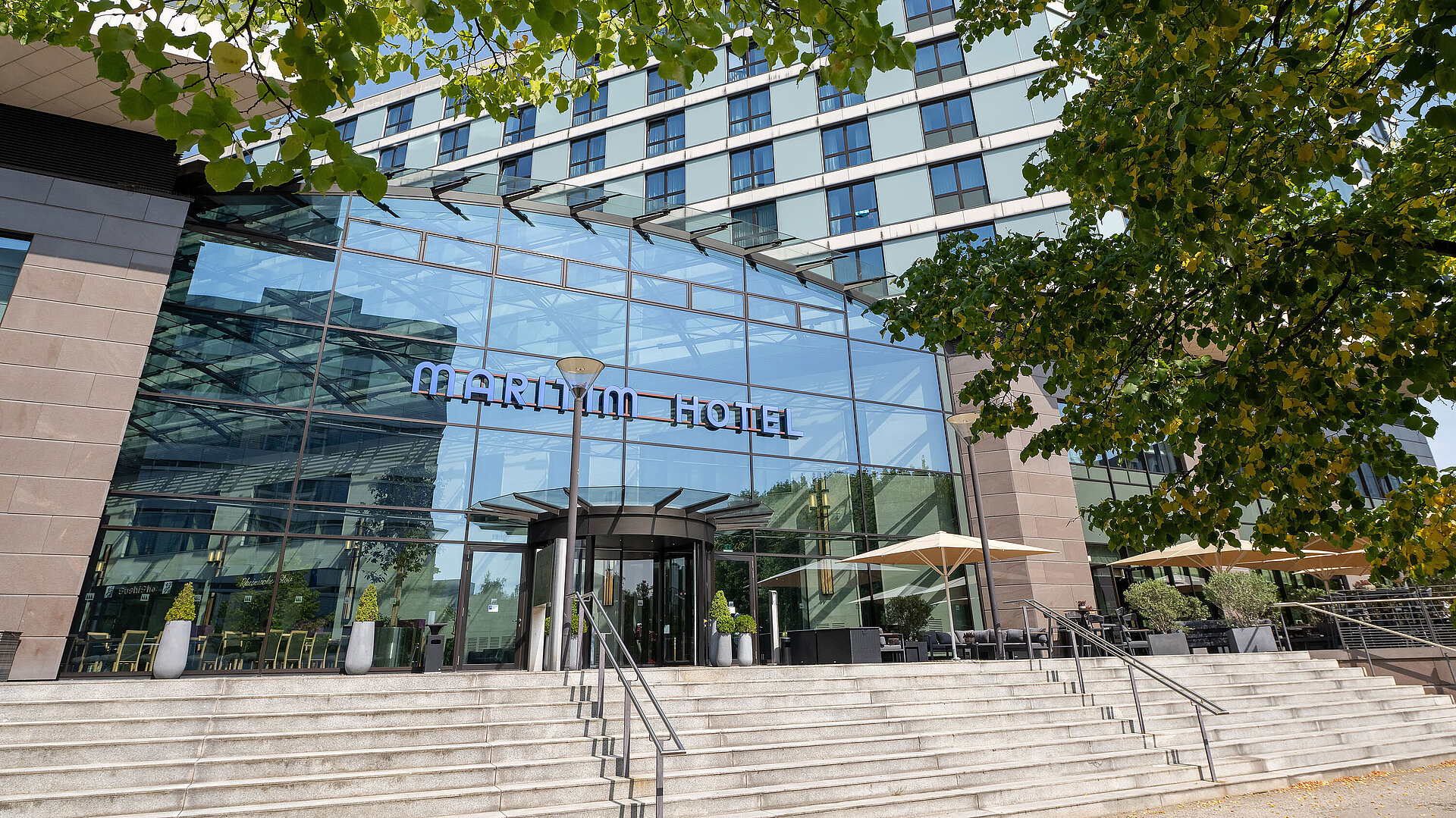 Main entrance of Maritim Hotel Düsseldorf with large glass façade and staircase