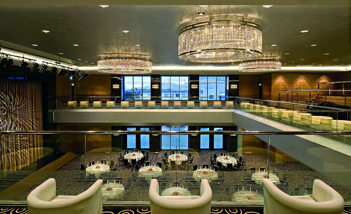 Elegant hall at Maritim Hotel Düsseldorf with impressive chandeliers, modern architecture, and a large stage.