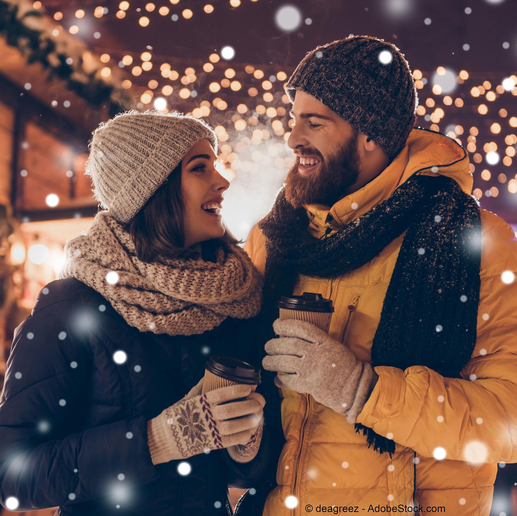 © deagreez - AdobeStock.com Couple enjoying hot drinks at a wintry Christmas market