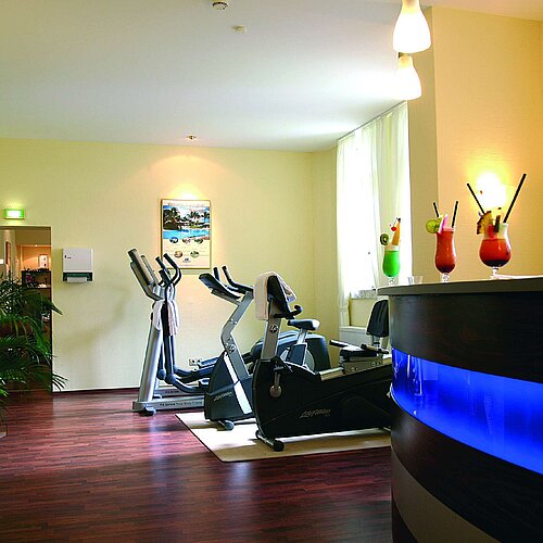Sala fitness luminosa al Maritim Hotel Bad Wildungen con bancone e attrezzi cardio