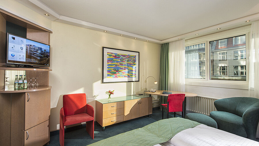 Bright Classic room at Maritim proArte Hotel Berlin with modern decor, cozy seating area, and city view.