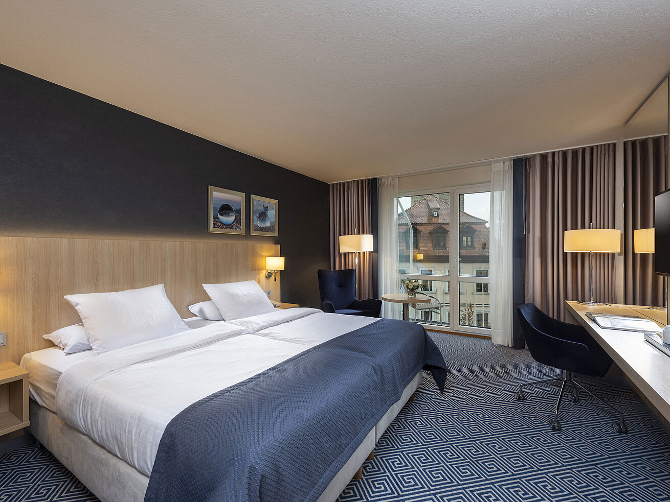 Elegant Superior Room at Maritim Hotel Würzburg with a large double bed and view of historic rooftops