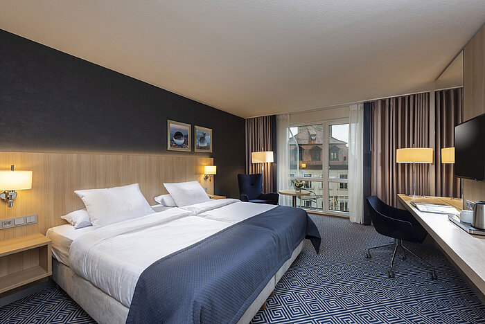 Chambre Supérieure élégante au Maritim Hotel Würzburg avec grand lit double et vue sur les toits historiques