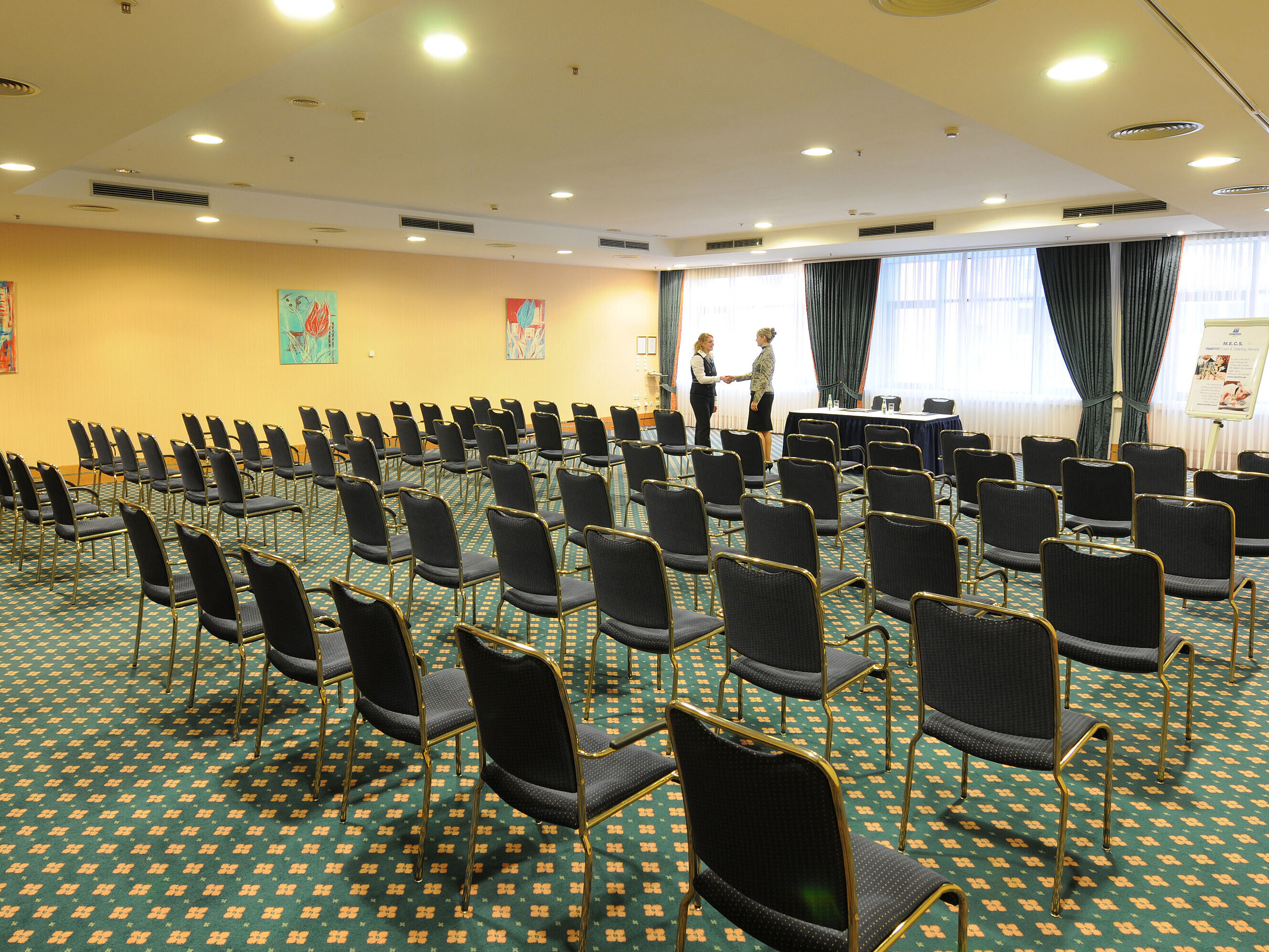Amplia sala de conferencias con asientos en fila y configuración profesional en el Maritim Hotel Magdeburg.