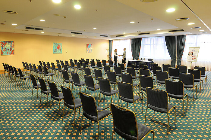 Amplia sala de conferencias con asientos en fila y configuración profesional en el Maritim Hotel Magdeburg.