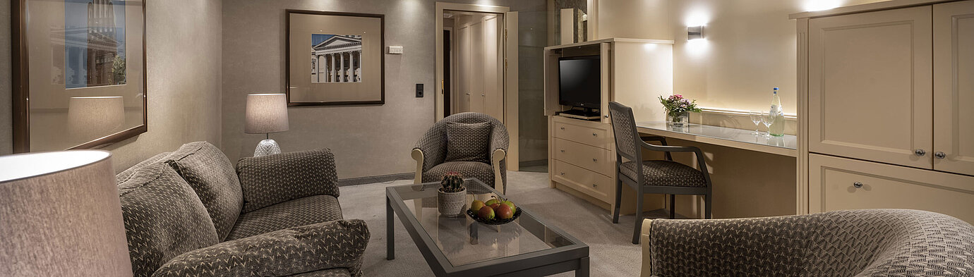  Elegante suite nel Maritim Hotel Darmstadt con un'accogliente area salotto, un'illuminazione elegante e una scrivania.