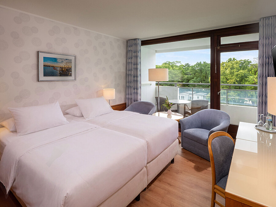 Classic Room with double bed, seating area, desk and large window overlooking the greenery