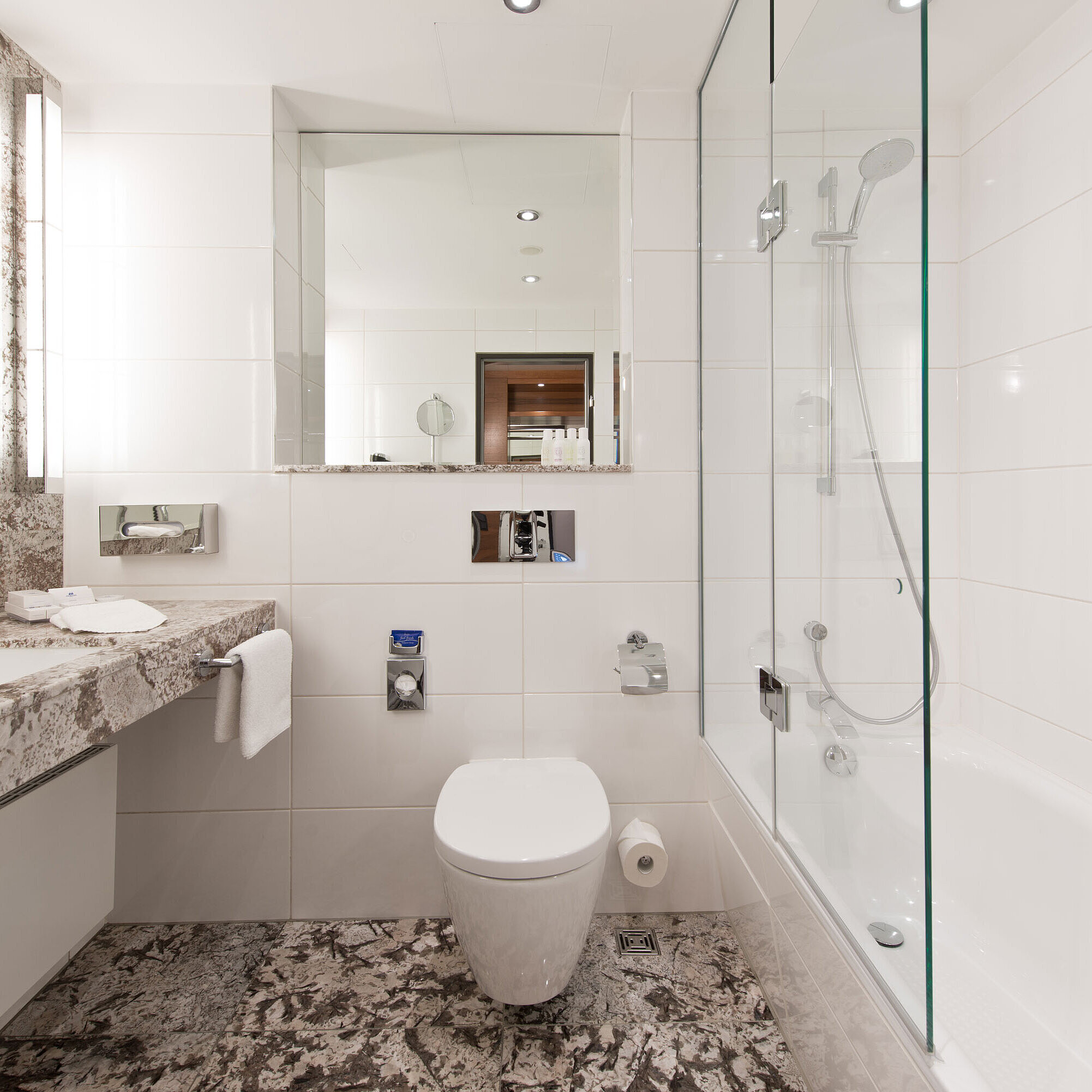 Baño Baño luminoso en el Hotel Maritim Bad Homburg con bañera moderna y diseño de mármol elegante.