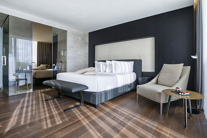 Chambre moderne au Maritim Hotel Plaza Tirana avec cloison vitrée, meubles design et parquet