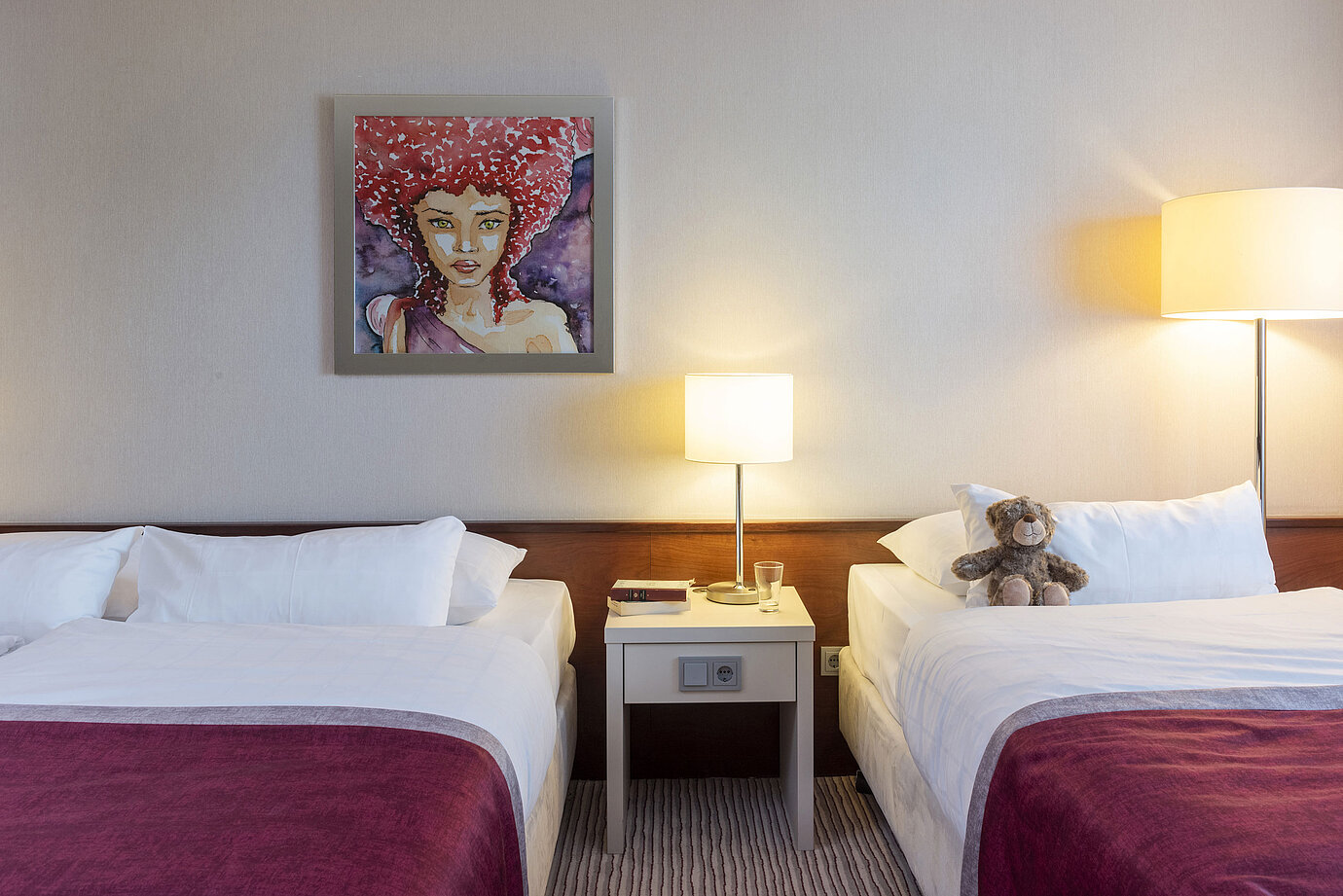 Camera familiare classica al Maritim Hotel Bonn con due letti, comodino e arte moderna per un soggiorno confortevole.