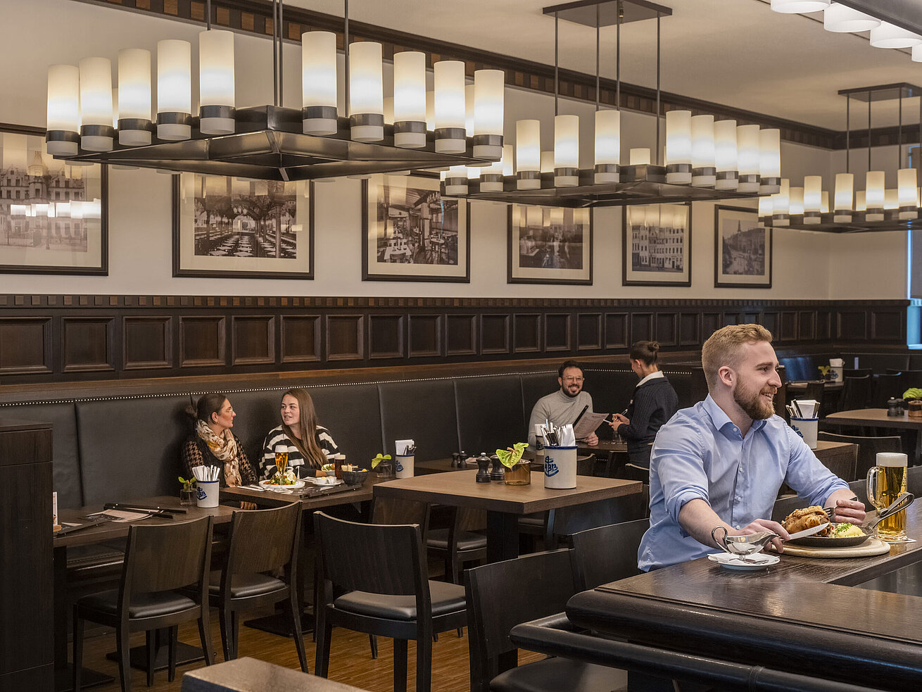 Guests enjoying meals in the cozy "Rheinische Stov" restaurant at Maritim Hotel Düsseldorf with stylish interior and ambiance