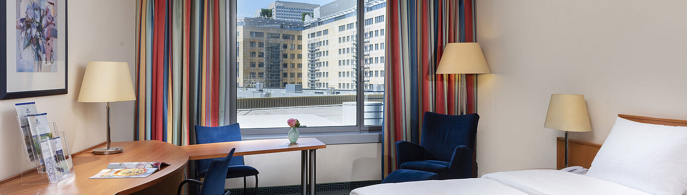 Chambre Classic du Maritim Hotel Frankfurt avec lit double confortable, bureau et vue sur la ville.