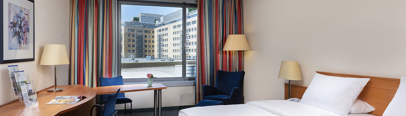 Chambre Classic du Maritim Hotel Frankfurt avec lit double confortable, bureau et vue sur la ville.