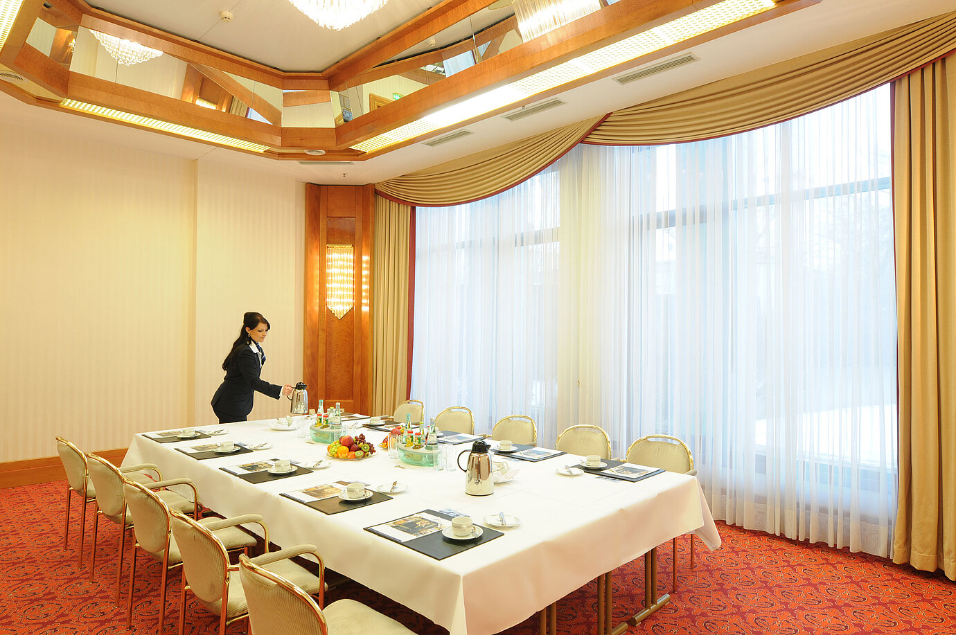Sala de reuniones elegante con luz natural, mesa preparada y ambiente cálido en el Maritim Hotel Magdeburg.