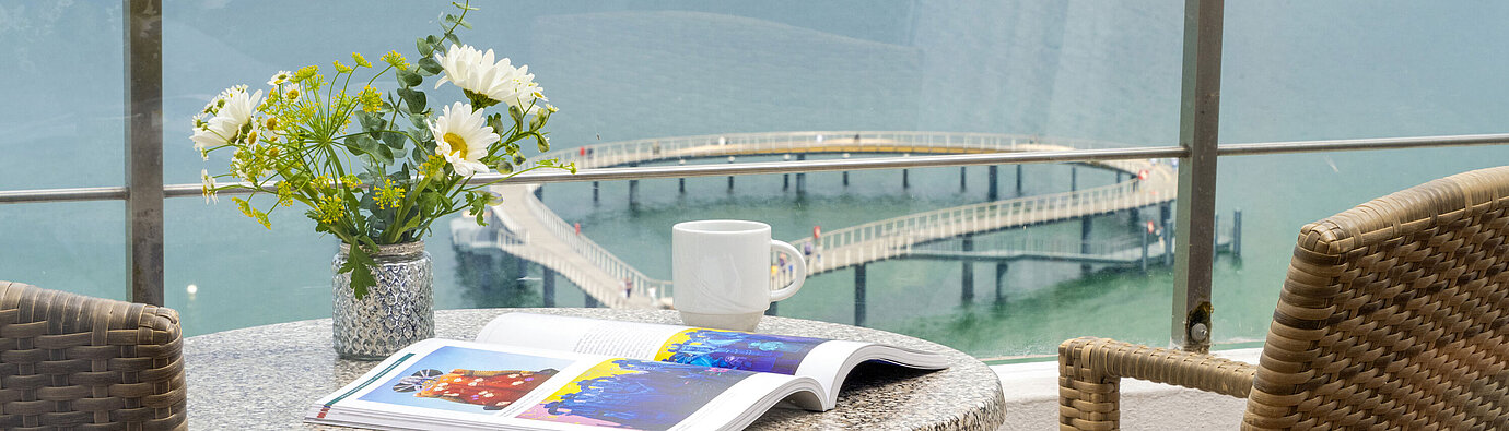 Balcón con vista al mar Balcón en el Maritim Seehotel Timmendorfer Strand con mesa, sillas y vistas al Báltico