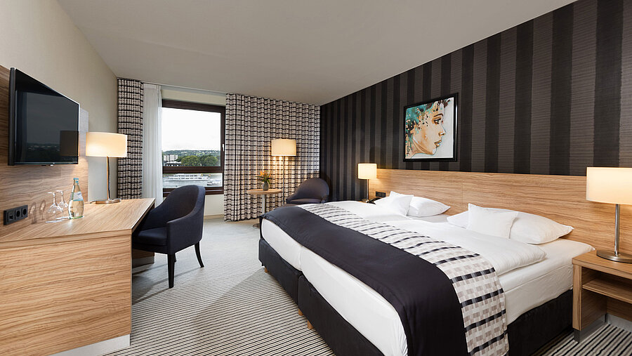 Chambre double élégante de l'hôtel Maritim Königswinter avec vue sur le Rhin et design moderne.