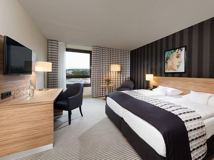Habitación doble elegante del Maritim Hotel Königswinter con vistas al Rin y diseño moderno.
