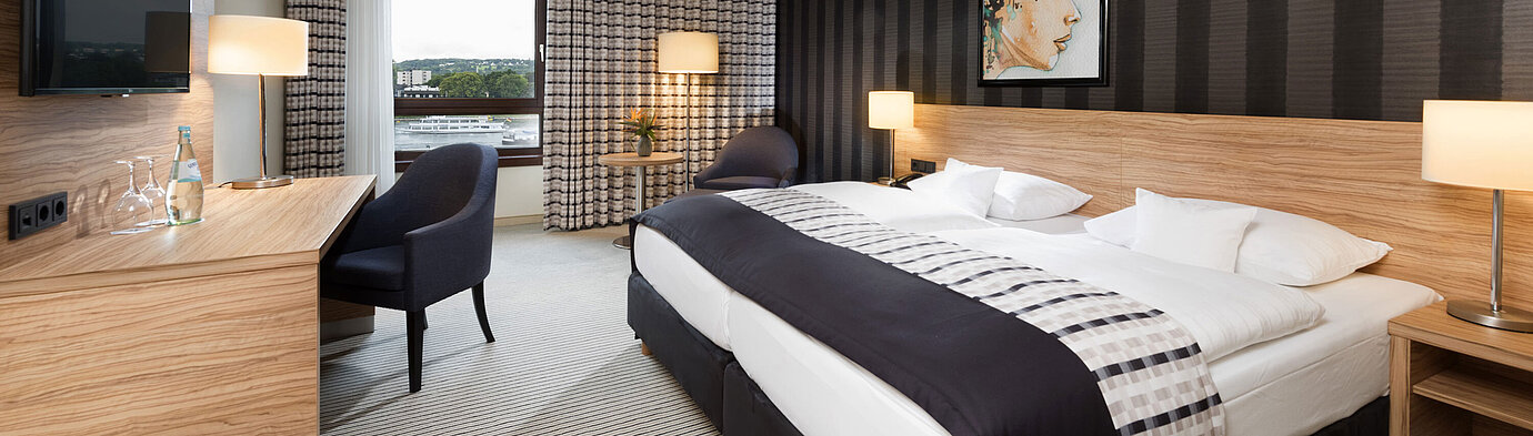 Chambre double élégante de l'hôtel Maritim Königswinter avec vue sur le Rhin et design moderne.