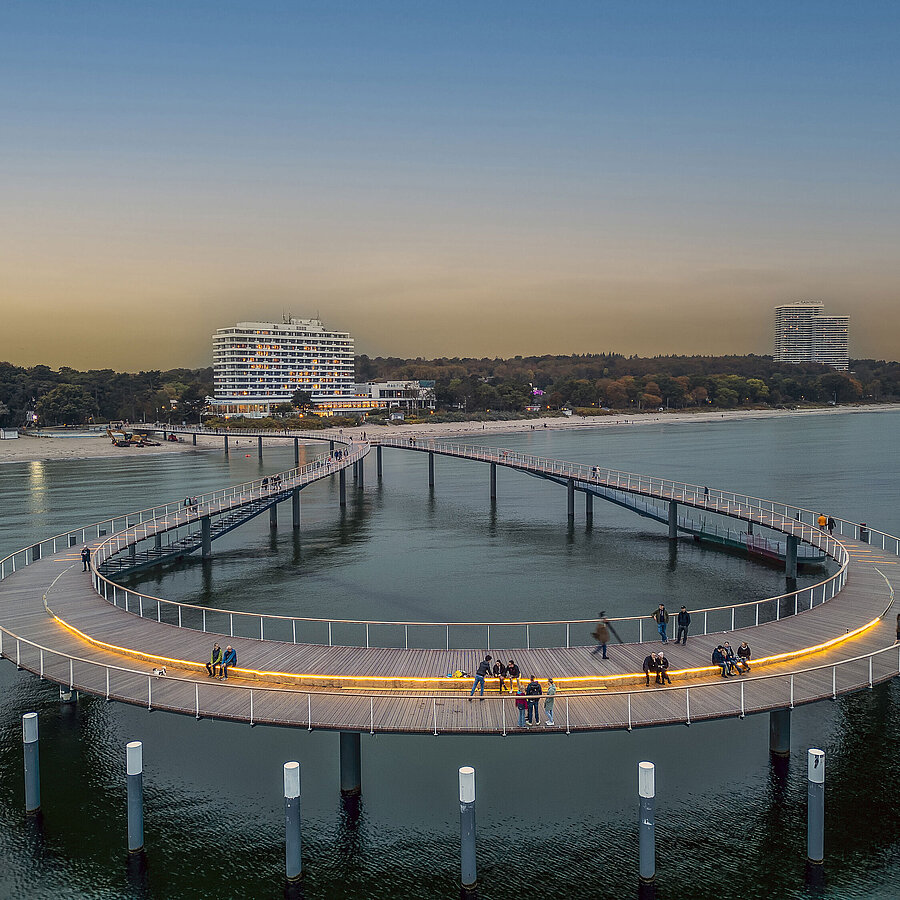 Maritim Seebrücke (molo) Pontile illuminato al crepuscolo davanti al Maritim Seehotel Timmendorfer Strand.
