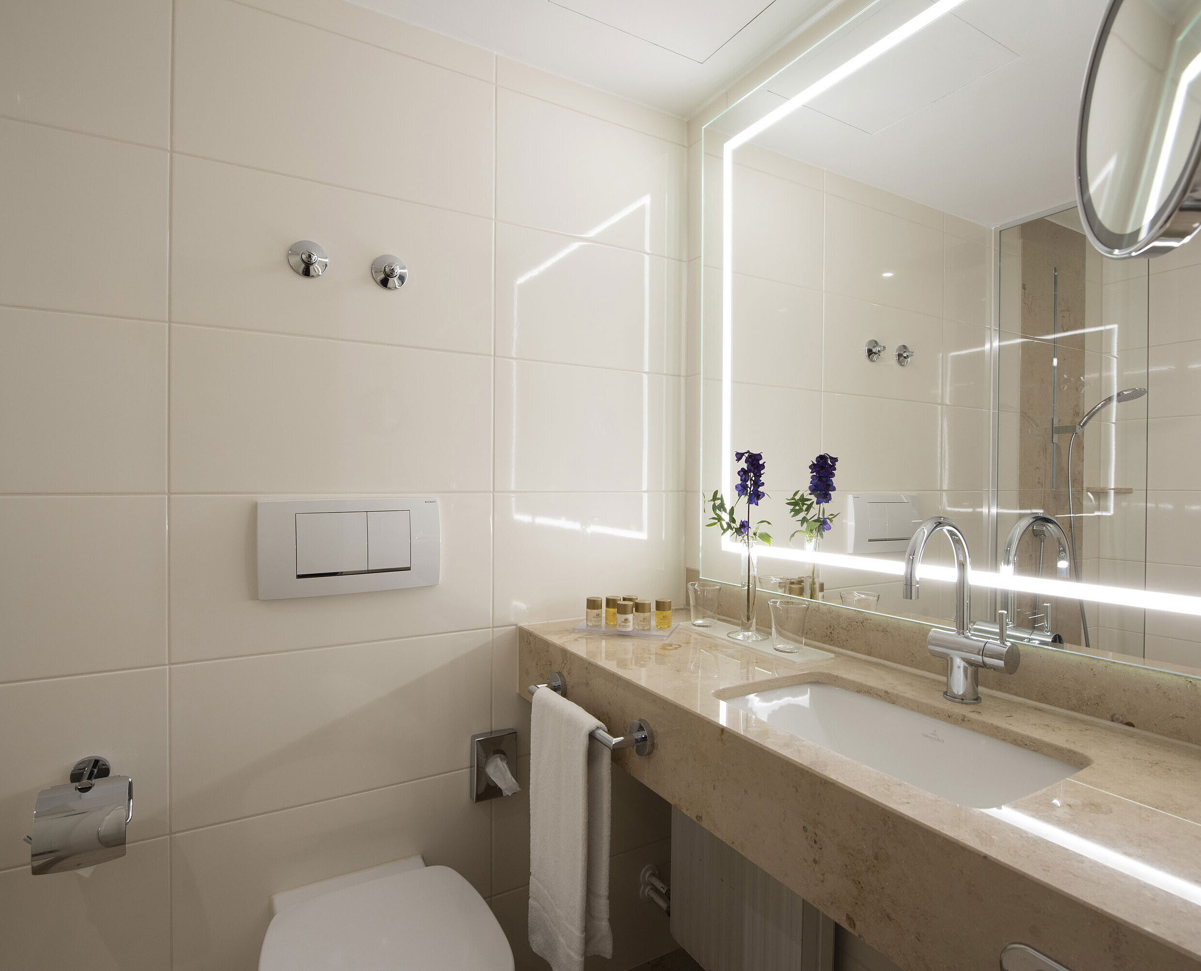 Bathroom Bright bathroom with large mirror and amenities at Maritim Hotel Titisee