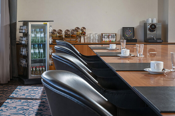 Sala de reuniones con cafetera, agua, tentempiés y sillas cómodas en el Maritim Hotel Travemünde