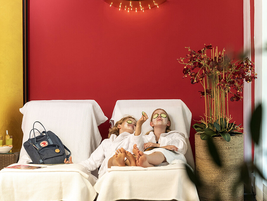 Deux filles avec masque facial et concombres se détendent au spa de l'hôtel Maritim, profitant de leur soin.