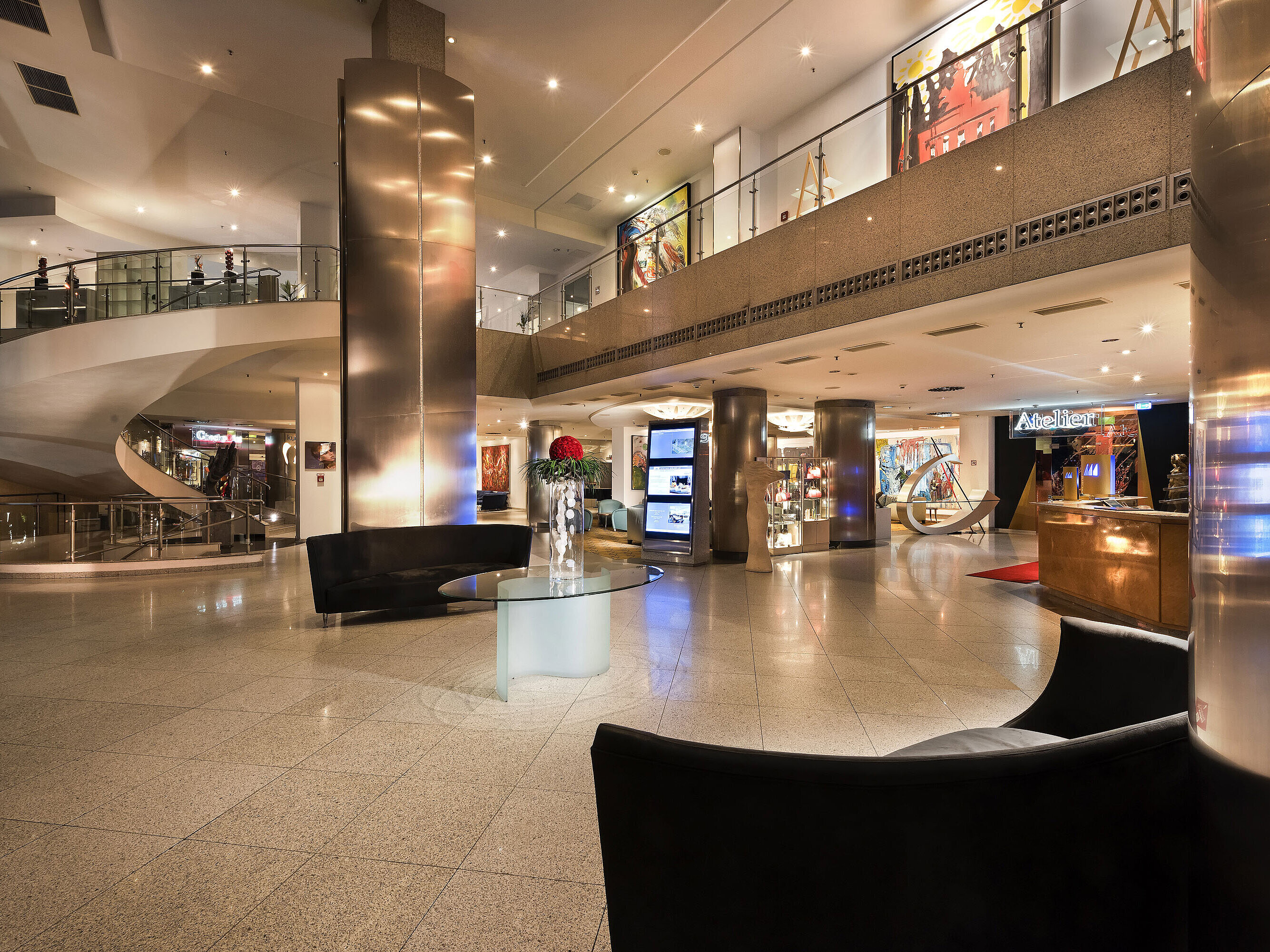 Stylish lobby with modern art and a curved staircase at the Maritim proArte Hotel Berlin.