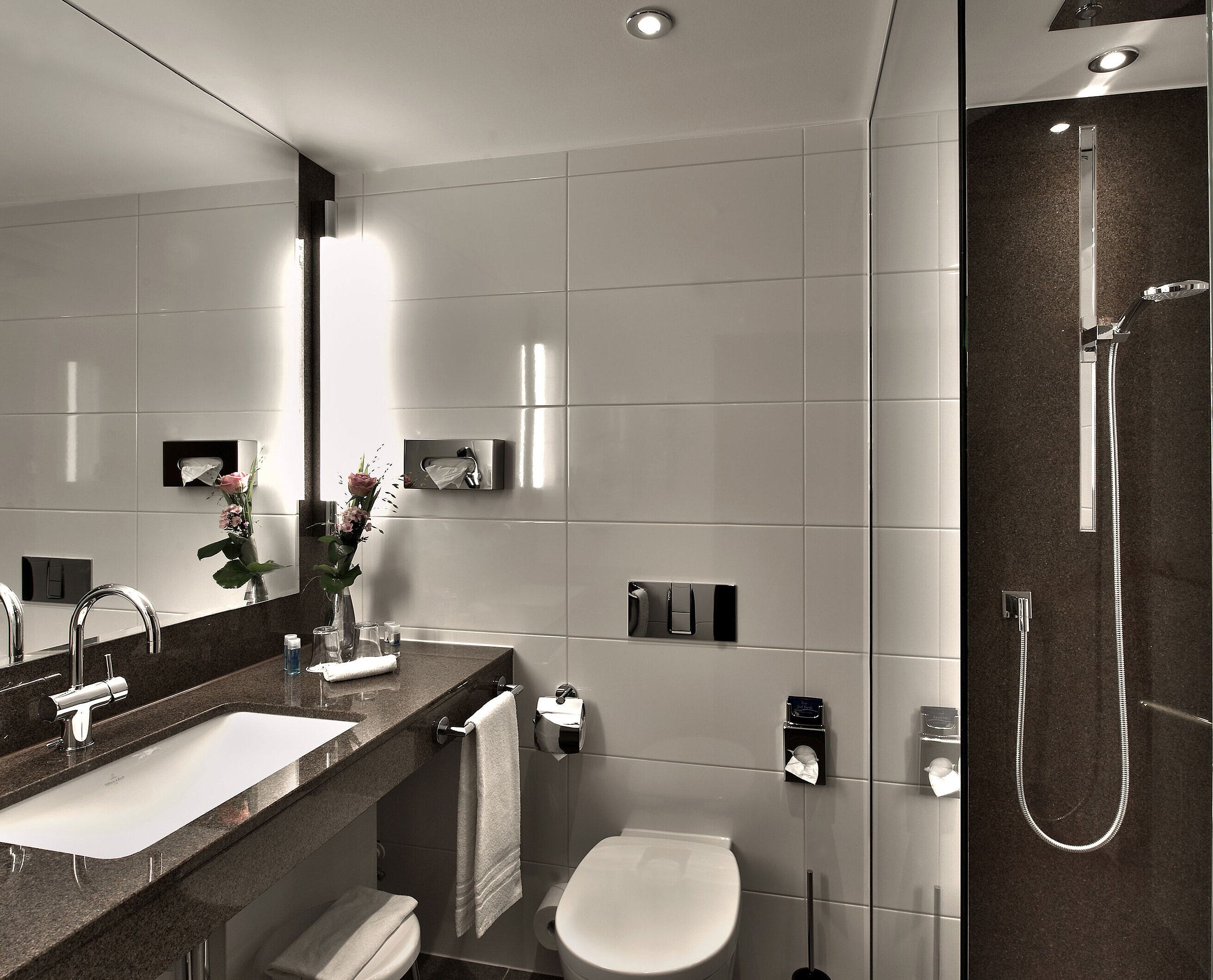 Bagno Bagno moderno al Maritim Hotel Colonia con vasca, grande specchio e illuminazione elegante in tonalità neutre.