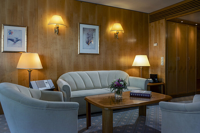 Coin salon confortable dans une suite de l'hôtel Maritim Magdeburg avec un mobilier élégant et une ambiance chaleureuse.
