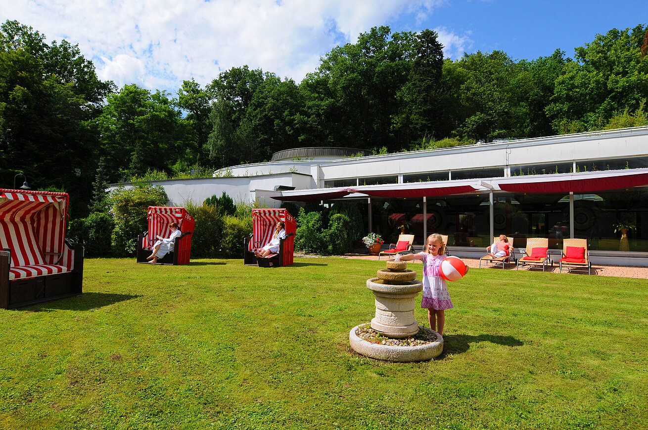 Giardino del Maritim Hotel Bad Wildungen con sedie da spiaggia, lettini e area giochi