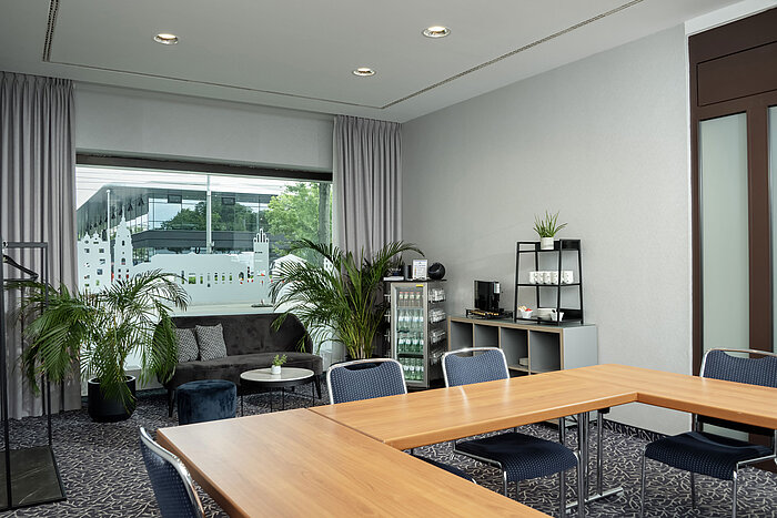 Salon Kiel con divano, piante e finestra al Maritim Hotel Darmstadt