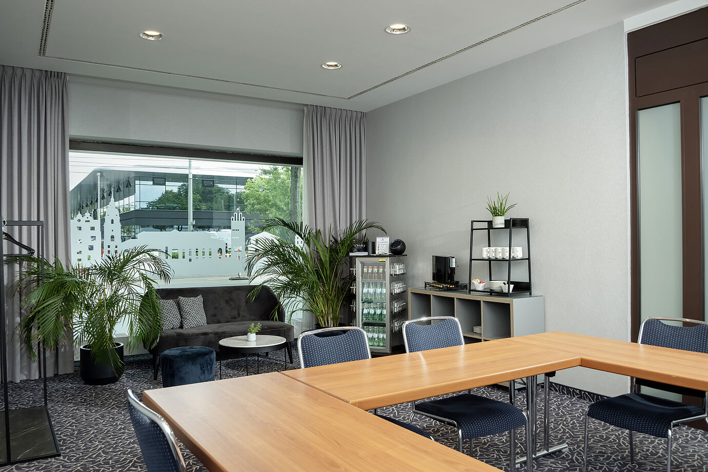 Salon Kiel con divano, piante e finestra al Maritim Hotel Darmstadt