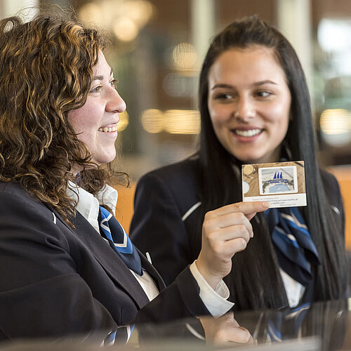 Smiling reception staff at Maritim Hotel Frankfurt presenting a room card.