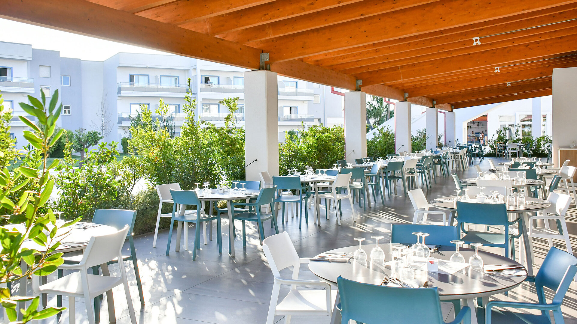 Zona esterna coperta e luminosa del ristorante al Maritim Resort Calabria con tavoli apparecchiati
