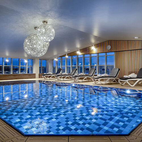 Zona wellness con lettini e piscina al Maritim Hotel Monaco