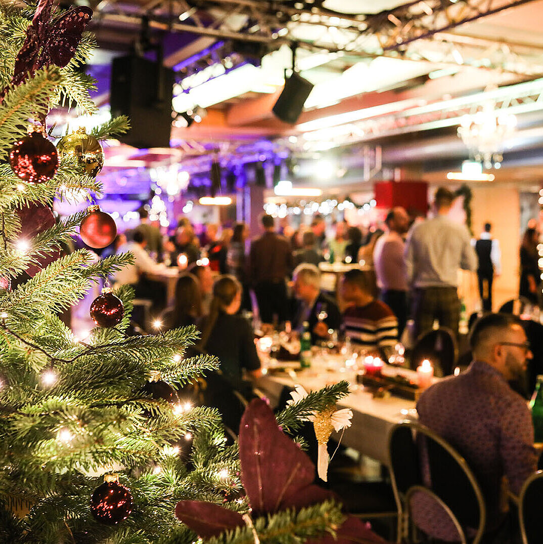 Christmas party with decorated tree and guests in a festive hall