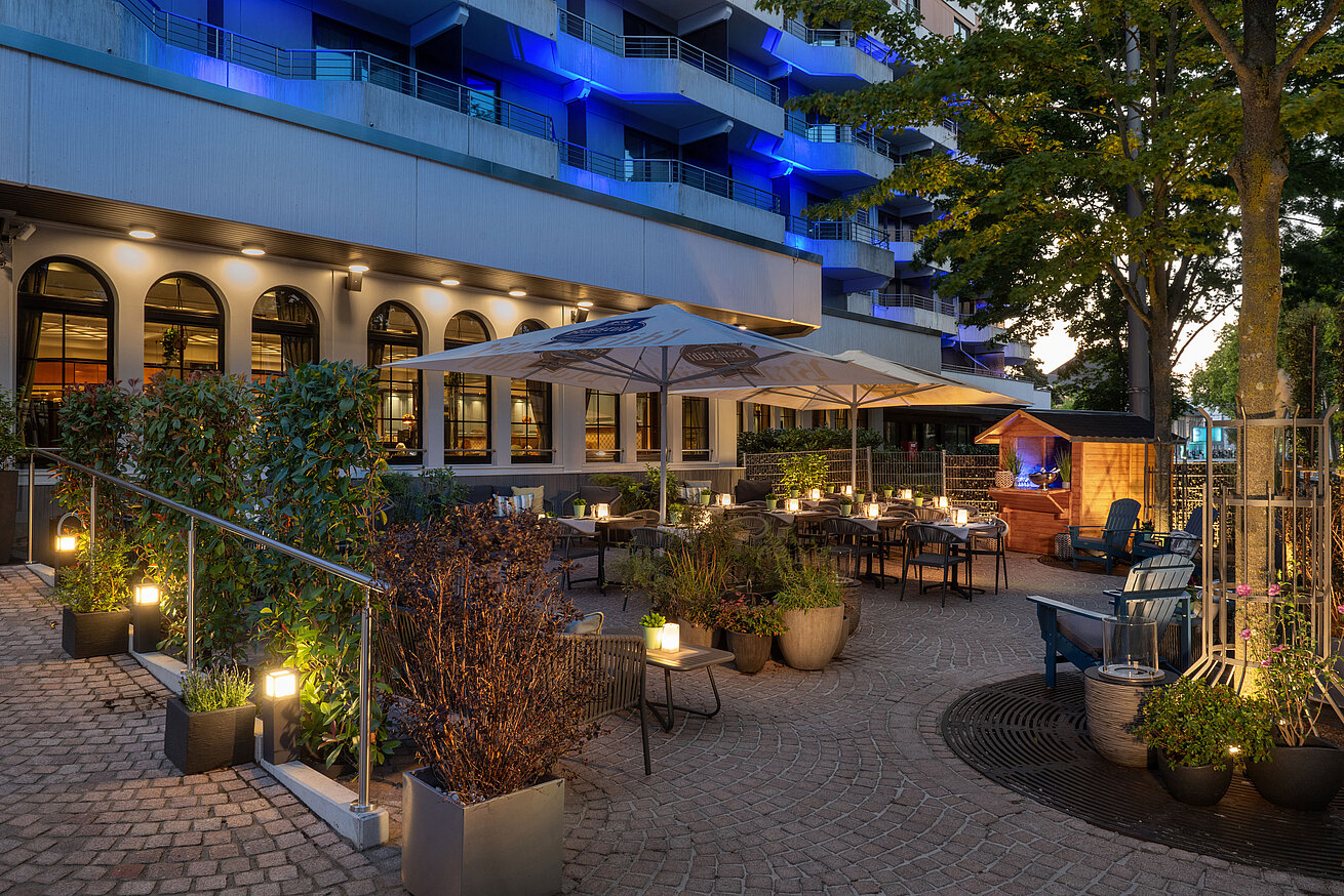 Terrace in the evening Illuminated restaurant terrace with outdoor seating and trees in the evening