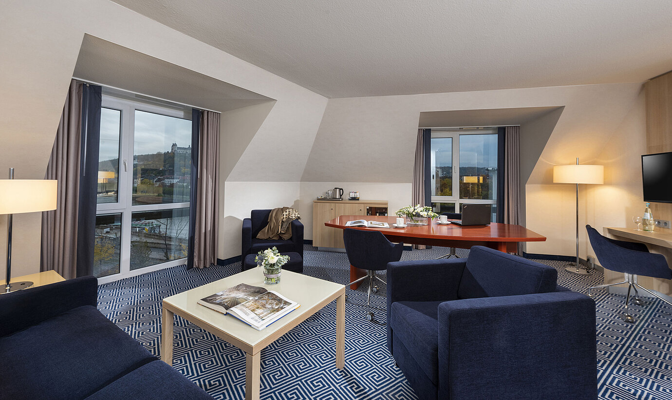 Ampia Grand Suite del Maritim Hotel Würzburg con area salotto e vista sulla Fortezza di Marienberg