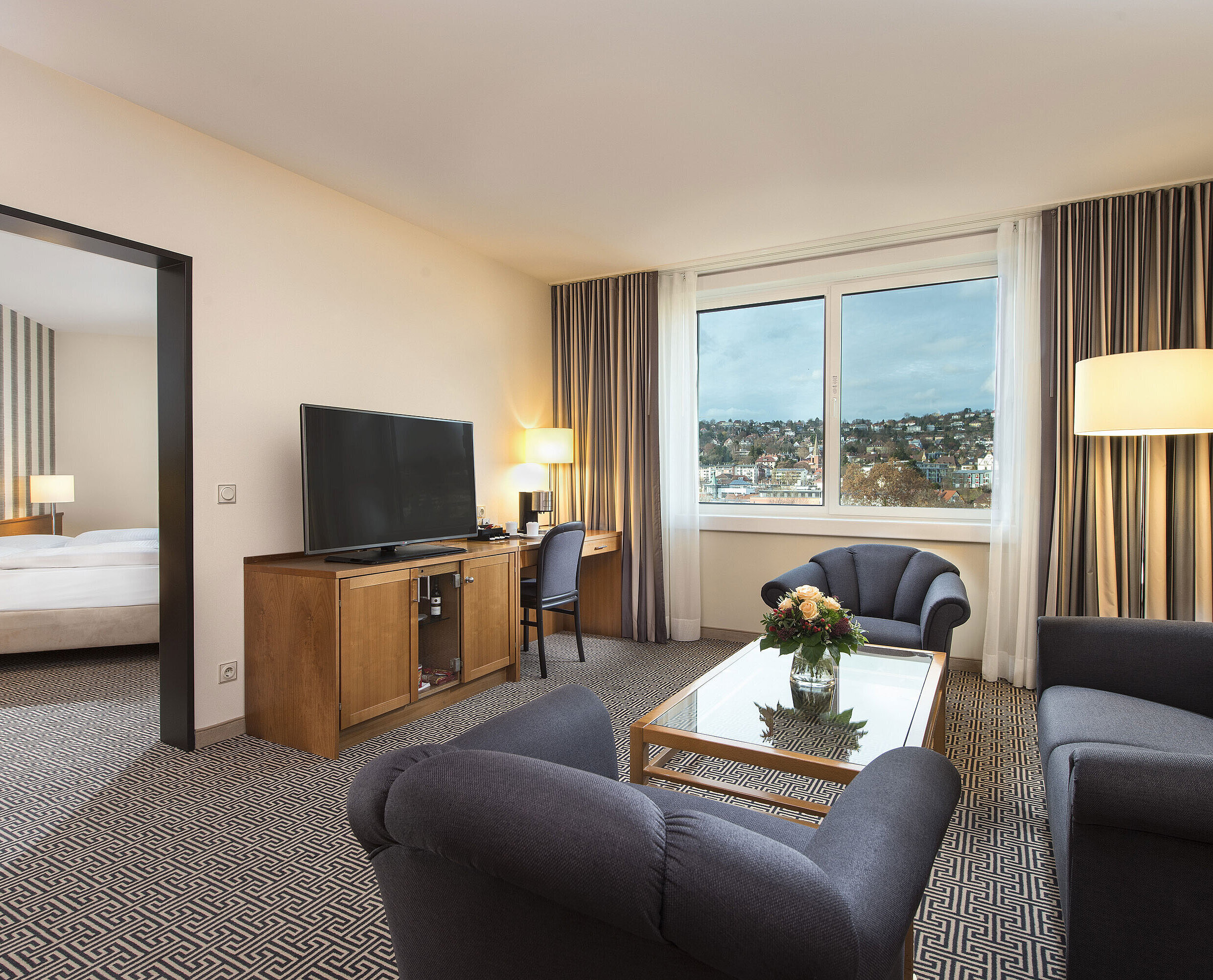 Suite Junior Suite lumineuse avec vue sur la ville, canapés, télé, bureau et chambre