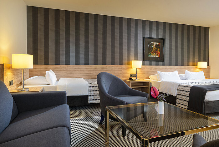 Chambre familiale moderne avec un design élégant et un coin salon cosy au Maritim Hotel Königswinter.