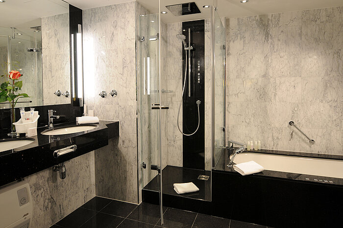 Bagno moderno con marmo, doccia, vasca e doppio lavabo al Maritim Hotel Monaco