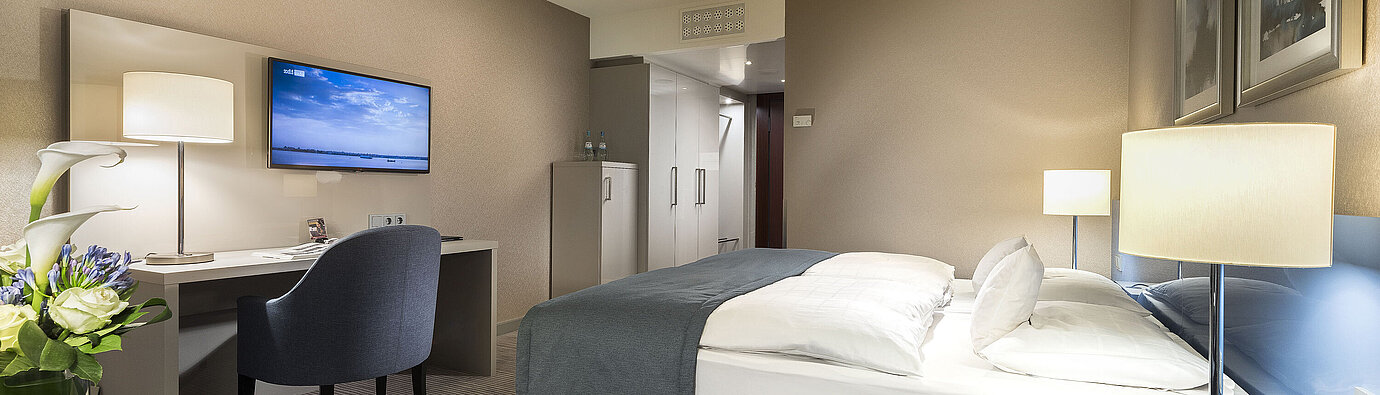 Camera Superior al Maritim Hotel Bonn con letto matrimoniale, scrivania, TV e arredamento moderno. Confortevole ed elegante.