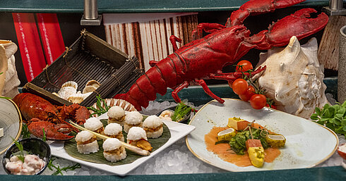 Lobster and seafood delicacies at the Maritim proArte Hotel Berlin buffet, decorated with tomatoes and seashells.