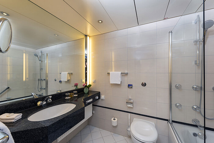 Bagno moderno del Maritim Hotel Frankfurt con grande specchio, lavabo elegante e vasca-doccia.