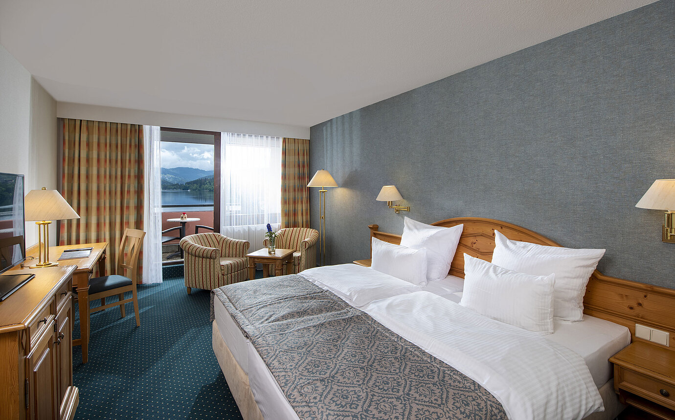 Spacious room at Maritim TitiseeHotel with seating area and view of Lake Titisee