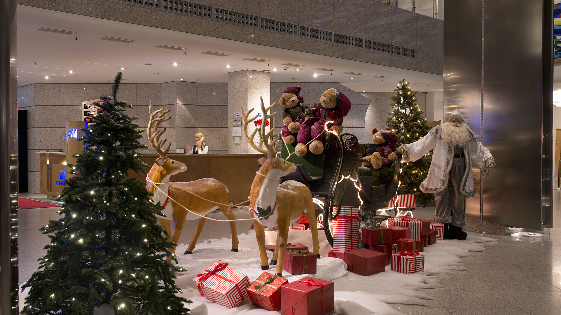 Festive decoration in the lobby of Maritim proArte Hotel Berlin with Santa Claus, reindeer, and gifts.