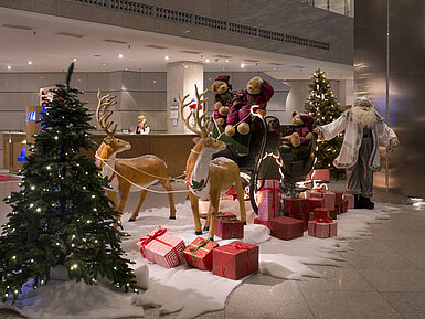 Festive decoration in the lobby of Maritim proArte Hotel Berlin with Santa Claus, reindeer, and gifts.