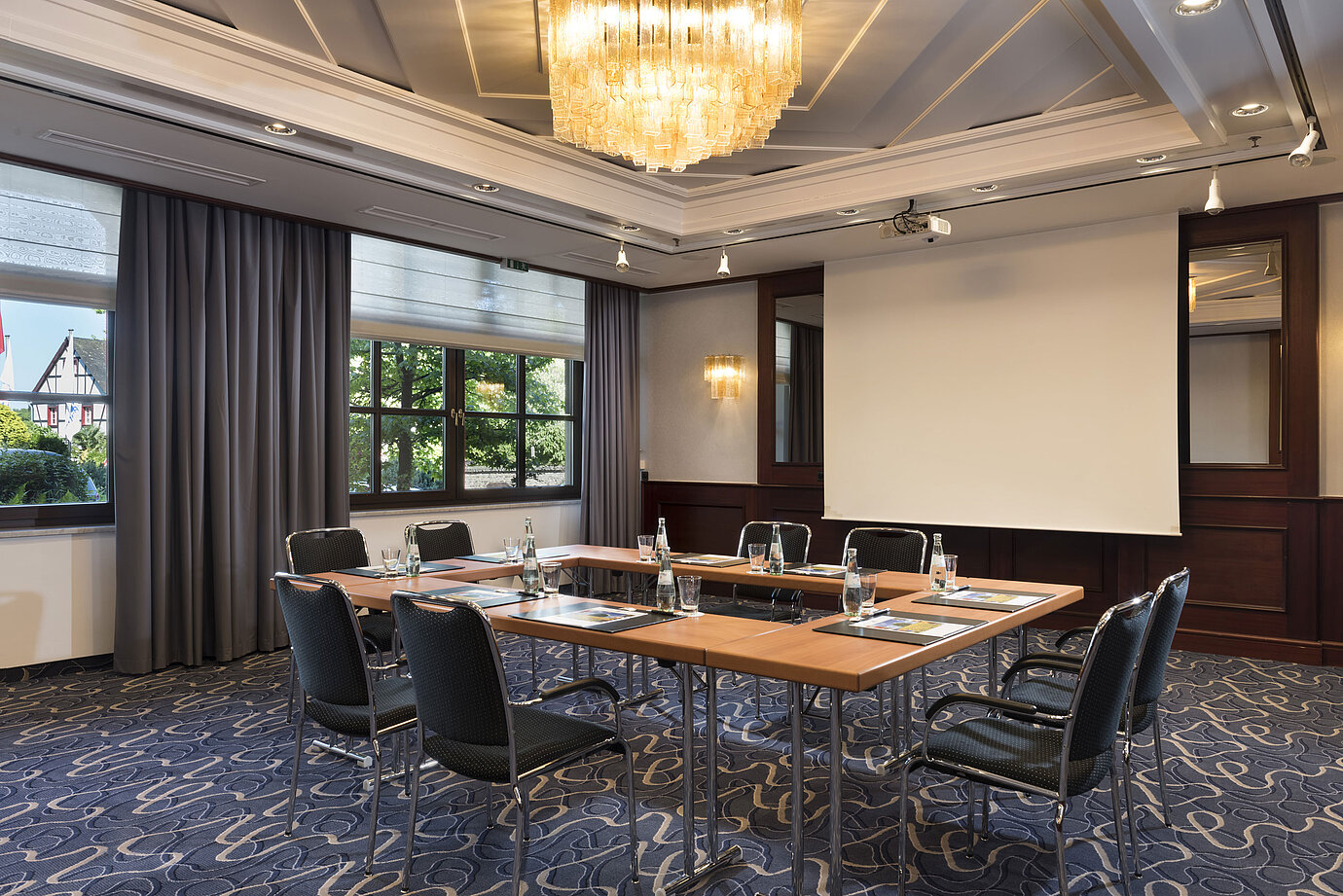 Sala de reuniones luminosa con tecnología moderna, grandes ventanas y lámpara elegante en Maritim Hotel Königswinter.